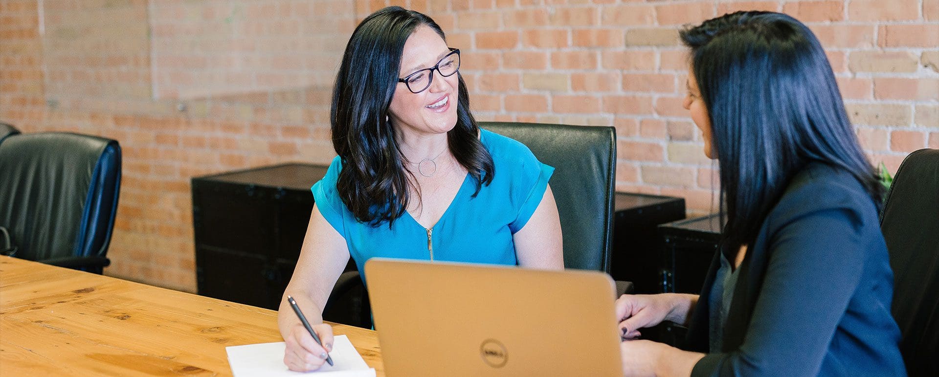 A woman sitting at a table with a laptop.